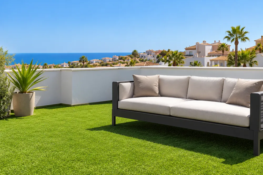 Terraza de un ático con césped artificial y sofá